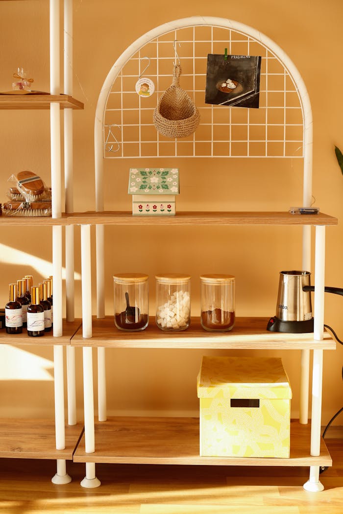 Bright kitchen shelf with jars, teapot, and decorative items. Warm, inviting ambiance.